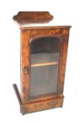 A Victorian walnut veneer glazed music cabinet.