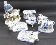 Seven Dutch delft cows and a Royal Copenhagen figure.