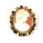 A vintage gold, garnet and shell cameo oval brooch.