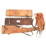 Two vintage leather gun cases, two gun sleeves and a leather cartridge belt.