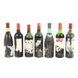 Seven bottles of vintage red wine.