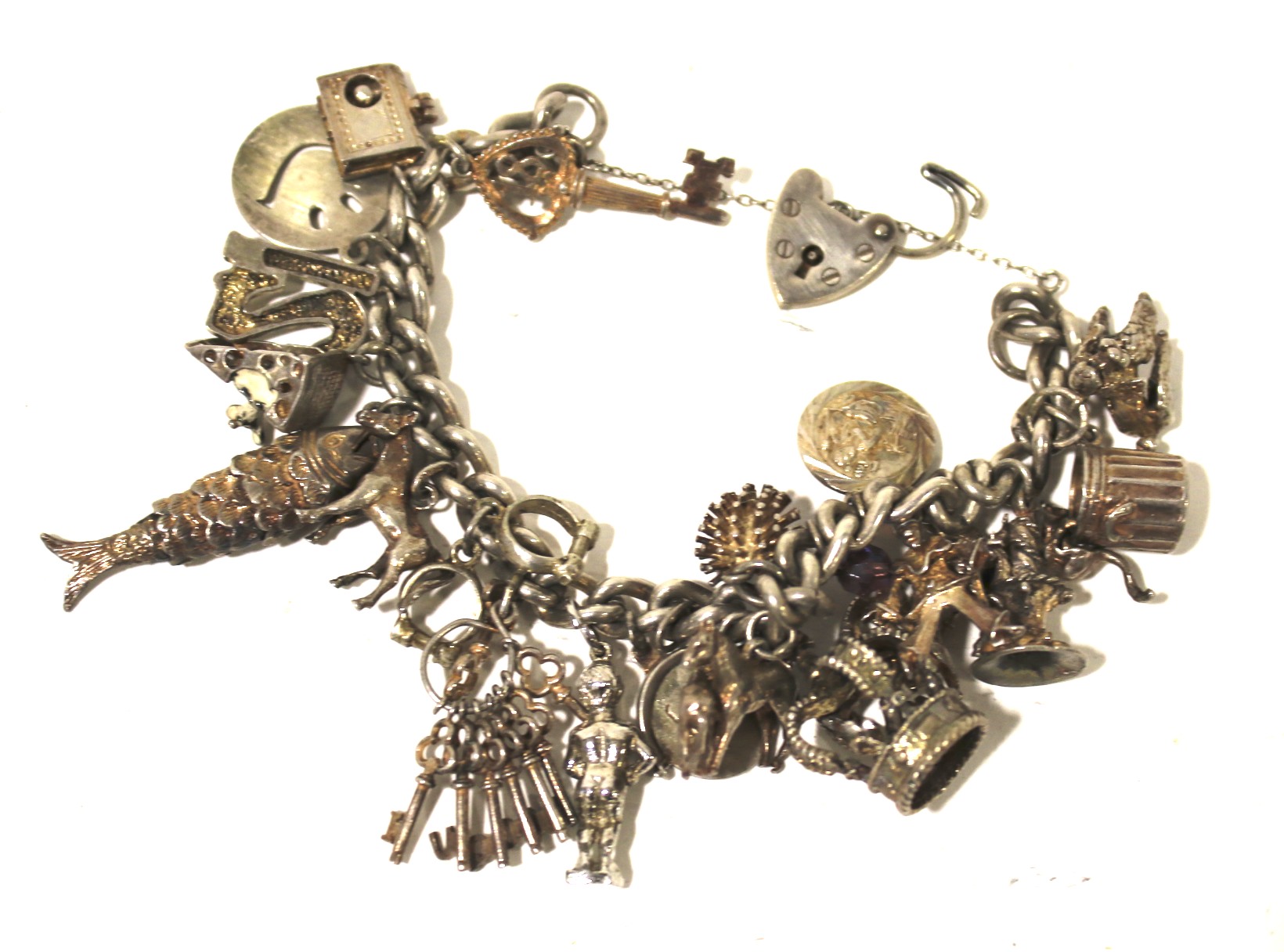 A silver charm bracelet with various silver and white metal charms.