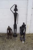 Three cast metal tribal figures. One in a standing position, the other two crouching.