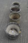 Four round stone composite garden pots. All with basket weave or brick pattern relief.