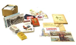 An assortment of cigarette cards, playing cards and postcards.