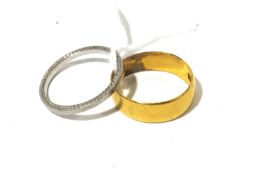 A 22ct gold wedding band and a platinum band. The 22ct gold band size I, 2.