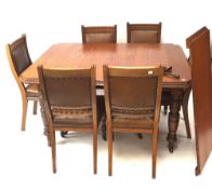 An Edwardian oak wind out dining table with extra leaf and set of six leather seated dining chairs.