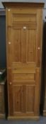 A contemporary tall pine kitchen cupboard. With two shelves behind each door, with turned knobs.