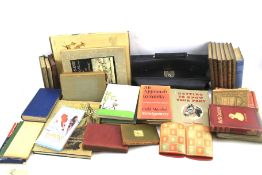 A quantity of vintage and modern books and a faux leather briefcase.