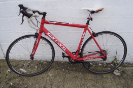 A red and white Carrera Zelos 6061 T6 racing bicycle.