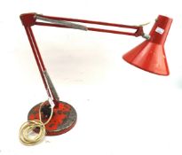 A vintage red anglepoise style lamp.