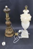 A cream alabaster table lamp and a gilt wood example. Both carved with leaves.