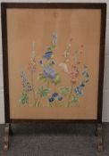 A 20th century stained wooden fire screen.