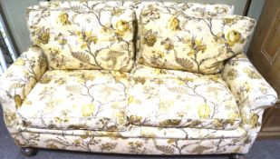 A Victorian sofa, upholstered in beige and yellow. With turned supports and casters.