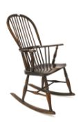 An elm Windsor rocking chair with spindle back and turned supports.