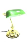 A modern bankers lamp with green shade on brass effect stand.