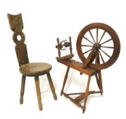 A Welsh oak spinning chair with central pierced hole, and a modern spinning wheel.
