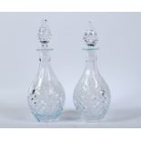 A pair of cut glass decanters and stoppers.