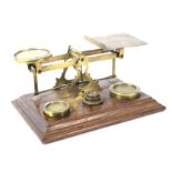A Victorian set of brass postal scales on mahogany base.