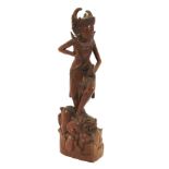 A 20th century Indonesian carved wooden figure of a dancer.