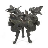 A bronze tripod footed cup in the Antique style with three pairs of spelter doves.