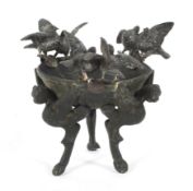 A bronze tripod footed cup in the Antique style with three pairs of spelter doves.