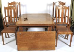 An oak Arts and Crafts wind out dining table and chairs.