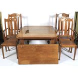 An oak Arts and Crafts wind out dining table and chairs.