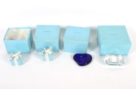 Two Tiffany & Co glass paperweights and two porcelain ribbon-tied boxes and covers.