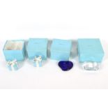Two Tiffany & Co glass paperweights and two porcelain ribbon-tied boxes and covers.