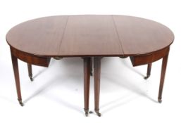 An Edwardian mahogany circular dining table with two extra leaves.