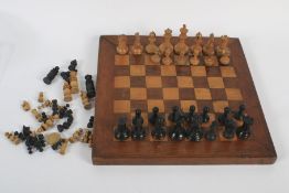 An early 20th century chess set and playing board dated to the verso 1910.