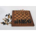 An early 20th century chess set and playing board dated to the verso 1910.