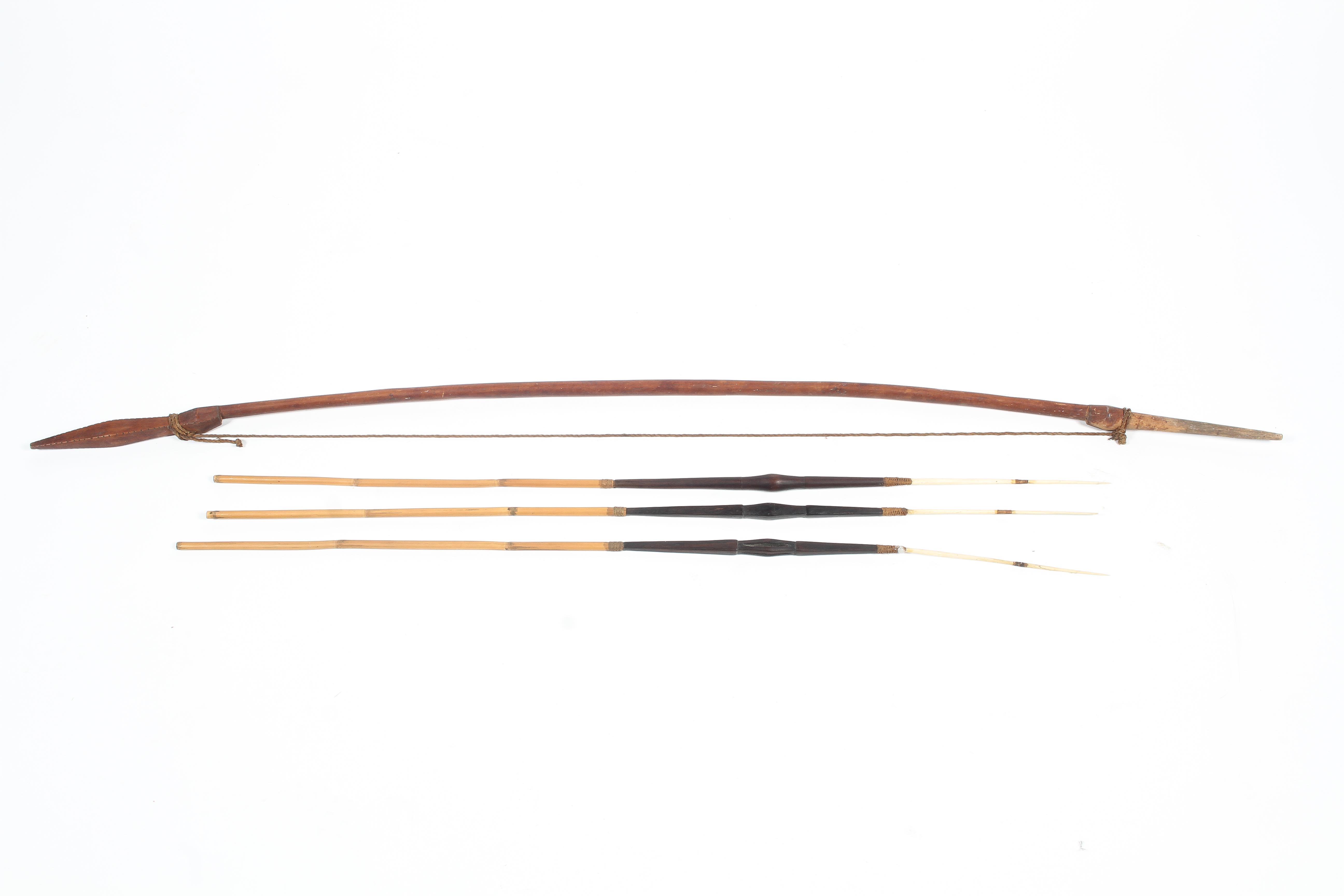 A Solomon Islands hunting bow and arrows with carved bone heads.