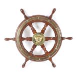A six-spoke mahogany and brass ship's wheel. Maker Simpson Lawrence, diameter 61cm.