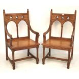 A pair of pitch pine ecclesiastical elbow altar chairs.
