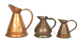 Three late 19th century copper graduated jugs. One stamped Gallon, The largest 41cm high max.