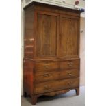 A Victorian flame mahogany linen press. The upper section with ebonised inlay to the paneled doors.