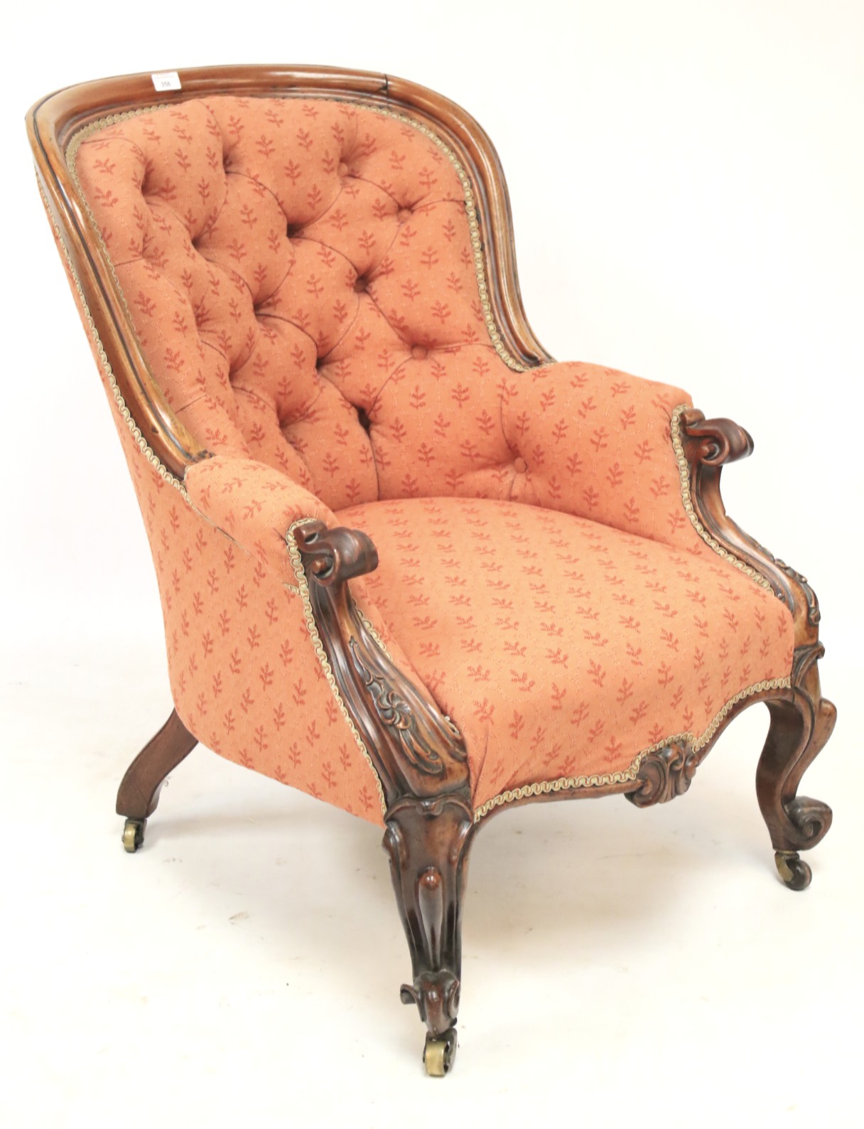 A Victorian upholstered mahogany button back armchair.