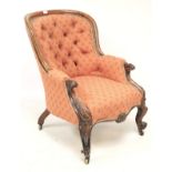 A Victorian upholstered mahogany button back armchair.