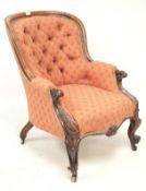 A Victorian upholstered mahogany button back armchair.