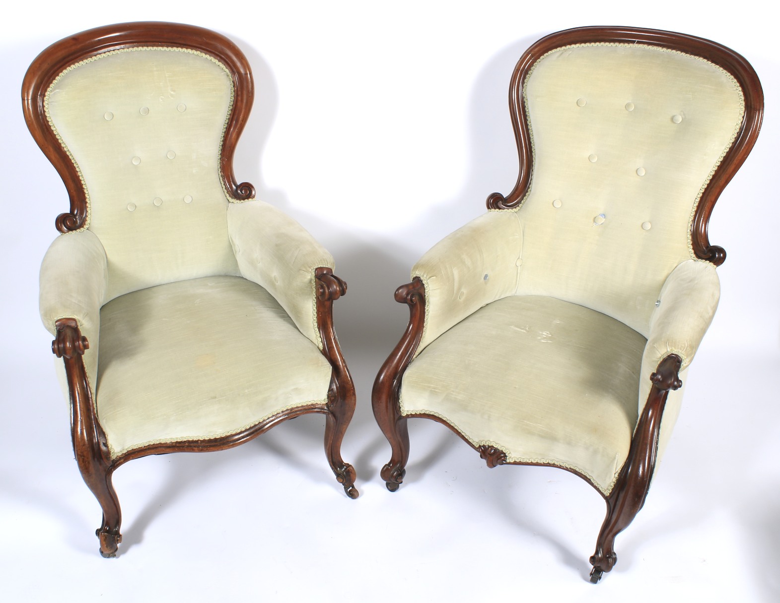 A pair of Victorian mahogany framed balloon-shaped button back armchairs.