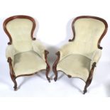 A pair of Victorian mahogany framed balloon-shaped button back armchairs.