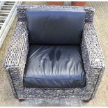 A contemporary wicker armchair with cushions.