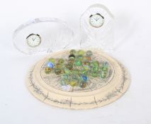 Two carved crystal mounted clocks and a decorative solitaire board with marbles.