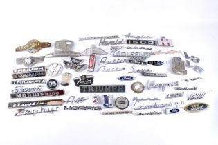 A large assortment of vintage car and vehicle badges.