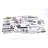 A large assortment of vintage car and vehicle badges.