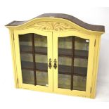 A painted, arched top glazed wall cabinet. The glazed doors to two internal shelves.