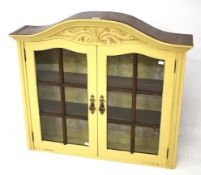 A painted, arched top glazed wall cabinet. The glazed doors to two internal shelves.