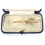 A 15ct gold diamond set brooch. Adorned with a heart motif, with centrally set diamond.